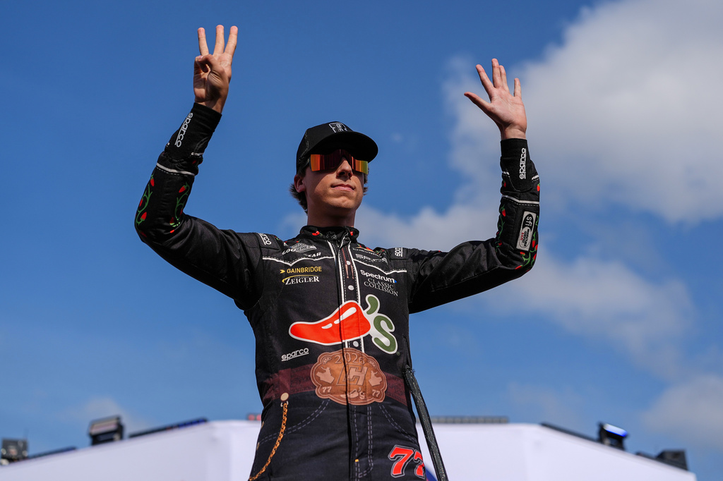 Carson Hocevar holds up eight fingers in honor of late driver Kyle Busch prior to a NASCAR Cup Series auto race, Sunday, May 24, 2026, in Charlotte, N.C. (AP Photo/Matt Kelley)