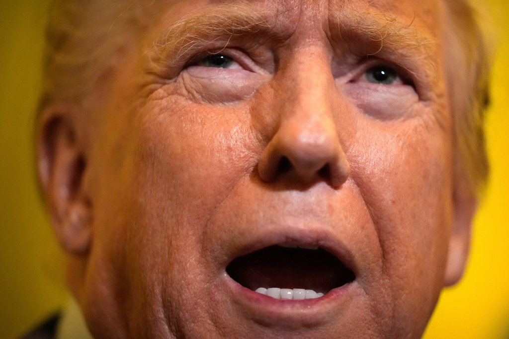 President Donald Trump speaks to reporters aboard Air Force One, Sunday, Oct. 19, 2025, en route to Joint Base Andrews, Md., as he returns from a trip to Florida. (AP Photo/Mark Schiefelbein)