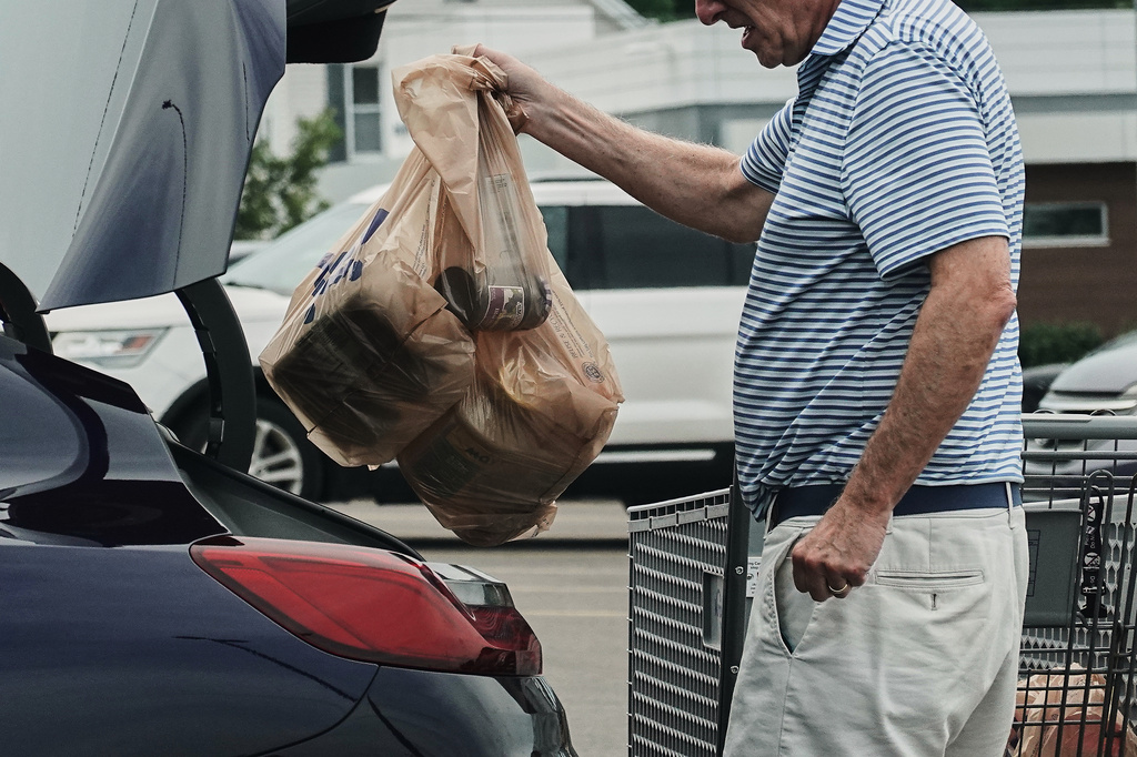 FILE - A person loads groceries in plastic bags into their vehicle, May 18, 2026, at a grocery store in Cincinnati. (AP Photo/Joshua A. Bickel, File)