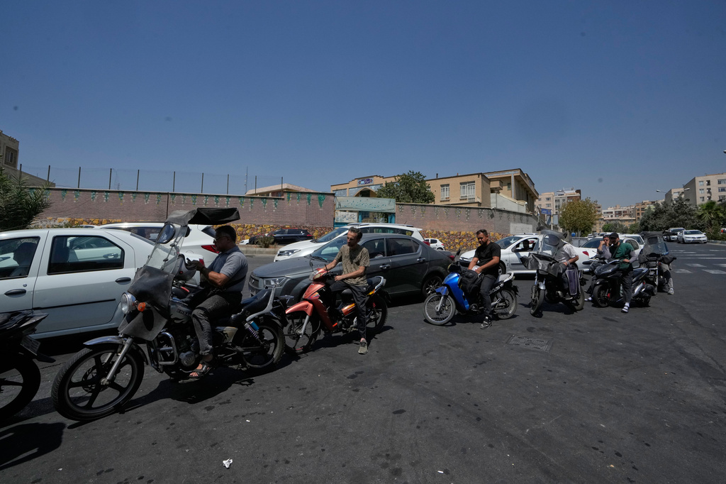 Motorcycles and cars line up outside a gas station in Tehran, Iran, Tuesday, Aug. 25, 2026. (AP Photo/Vahid Salemi)