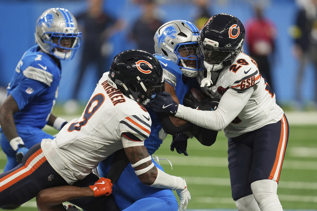 Detroit Lions running back David Montgomery, center, is hit by Chicago Bears9= and cornerback Tyrique Stevenson (29) during the second half of an NFL football game in Detroit, Sunday, Sept. 14, 2025. (AP Photo/Paul Sancya)