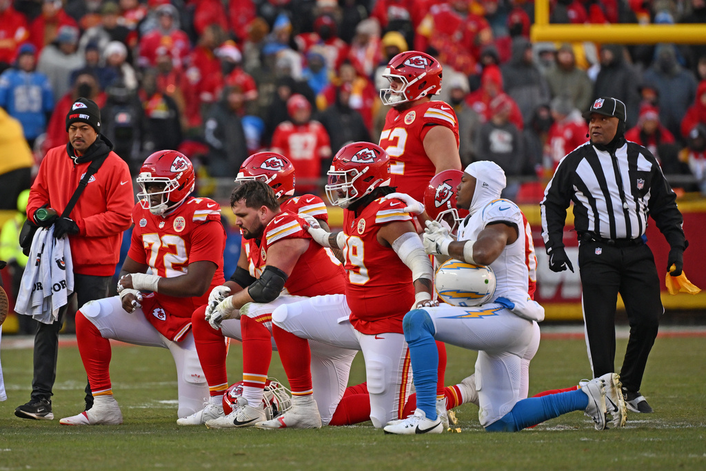 FILE - Kansas City Chiefs and Los Angeles Chargers players take a knee after Chiefs quarterback Patrick Mahomes (15) was injured during an NFL football game Sunday, Dec. 14, 2025, in Kansas City, Mo. (AP Photo/Peter Aiken, File)