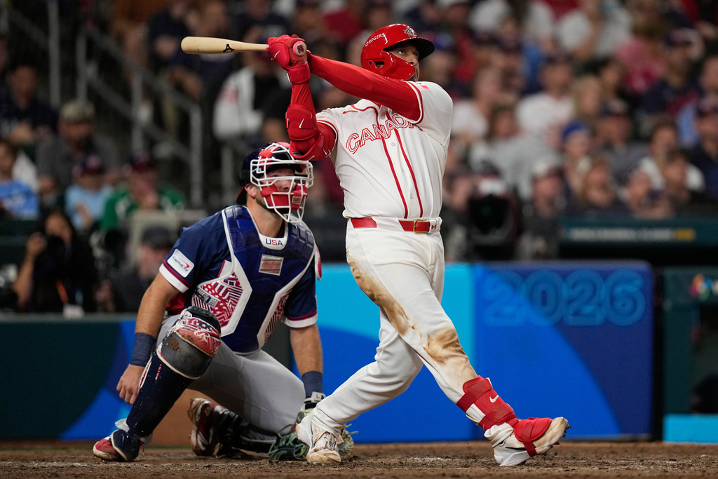 Canada catcher Bo Naylor, hits a two-run homer against the United States during the sixth inning of a World Baseball Classic quarterfinal game, Friday, March 13, 2026, in Houston. (AP Photo/David J. Phillip)