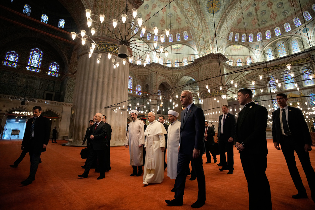 FILE - Pope Leo XIV, walking in white socks, visits the Blue Mosque in Istanbul, Turkey, Nov. 29, 2025. (AP Photo/Emrah Gurel, File)