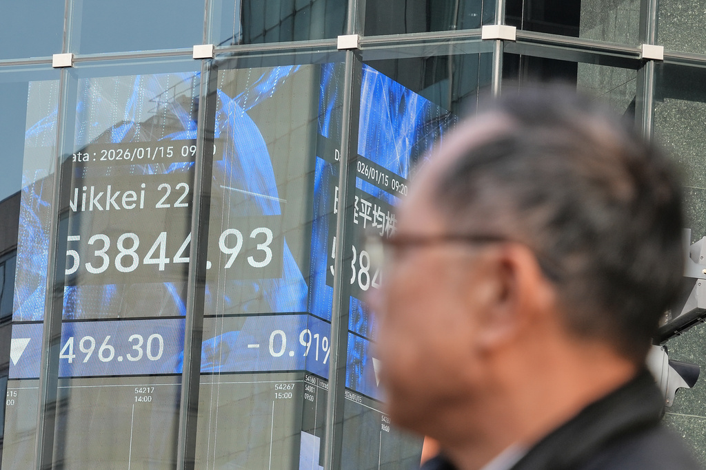 A person walks in front of an electronic stock board showing Japan's Nikkei index at a securities firm Thursday, Jan. 15, 2026, in Tokyo. (AP Photo/Eugene Hoshiko)