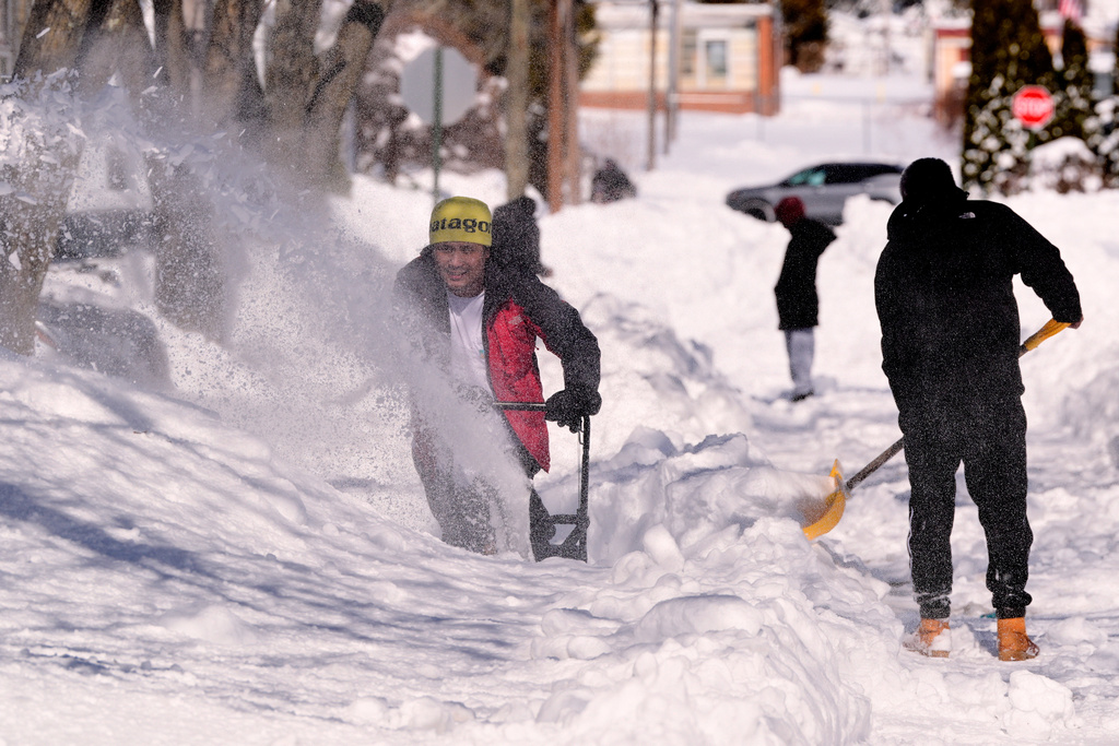 Matt Bableto, left, snowblows his driveway after a winter storm dumped about three feet of snow across the region, Tuesday, Feb. 24, 2026, in Cranston, R.I. (AP Photo/Charles Krupa)