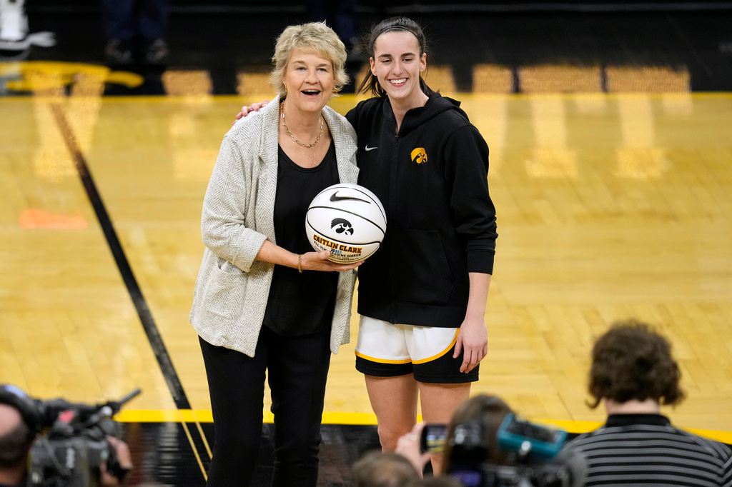 FILE - Iowa head coach Lisa Bluder, left, poses with guard Caitlin Clark during a ceremony honoring Clark for becoming the Big Ten's career scoring leader before an NCAA college basketball game against Penn State, Thursday, Feb. 8, 2024, in Iowa City, Iowa. (AP Photo/Charlie Neibergall, File)