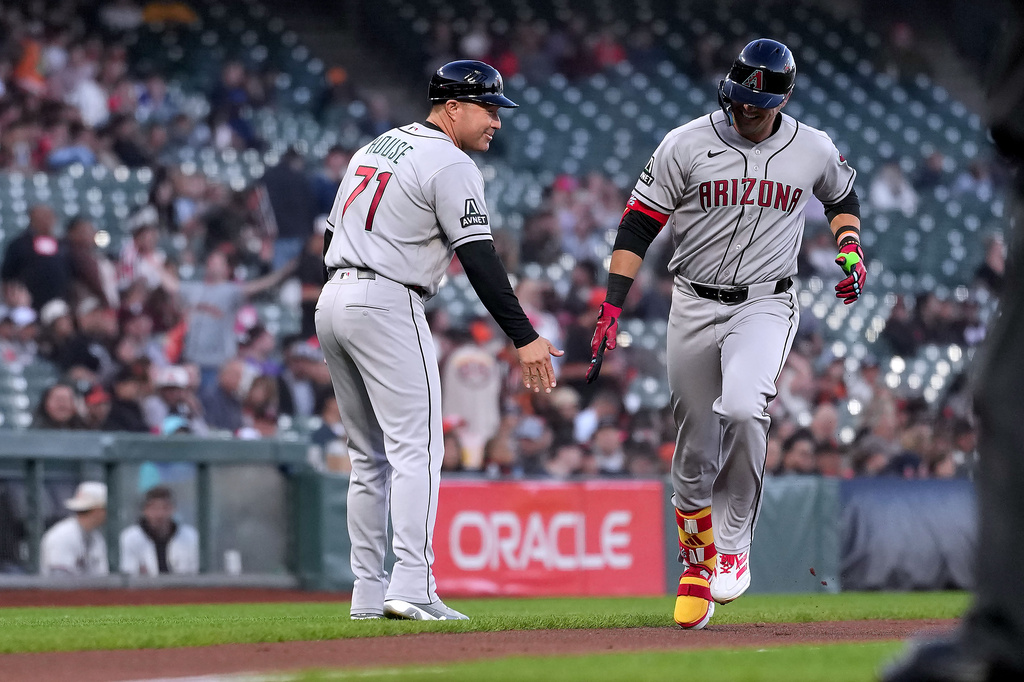 Arizona Diamondbacks' Lars Nootbaar, right, is congratulated by third base coach J.R. House (71) as he rounds the bases after hitting a home run against the San Francisco Giants during the first inning of a baseball game in San Francisco, Friday, Aug. 28, 2026. (AP Photo/Tony Avelar)