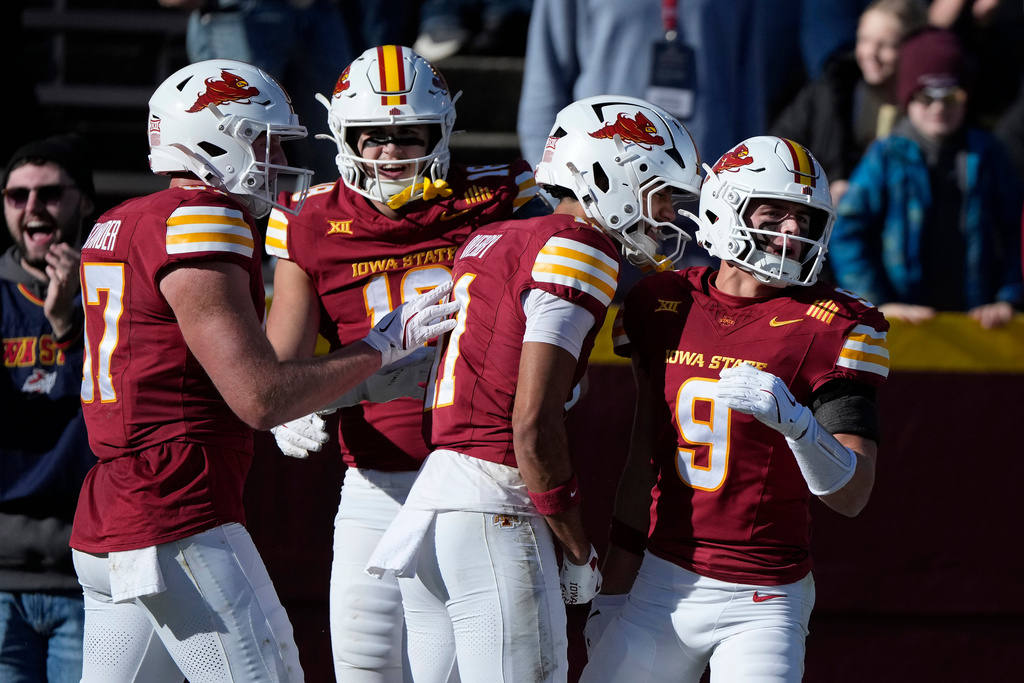 Iowa State wide receiver Brett Eskildsen (9) celebrates with teammates Cooper Alexander (87), Benjamin Brahmer (18) and Dominic Overby (11) after scoring a touchdown during the first half of an NCAA college football game against Kansas, Saturday, Nov. 22, 2025, in Ames, Iowa. (AP Photo/Matthew Putney)