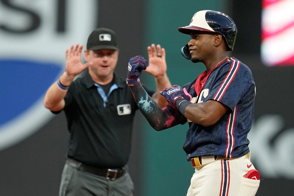 Cleveland Guardians' Angel Martínez gestures from second base in front of second base umpire Mike Muchlinski, rear, after hitting a double in the sixth inning of a baseball game against the Detroit Tigers in Cleveland, Friday, June 12, 2026. (AP Photo/Sue Ogrocki)