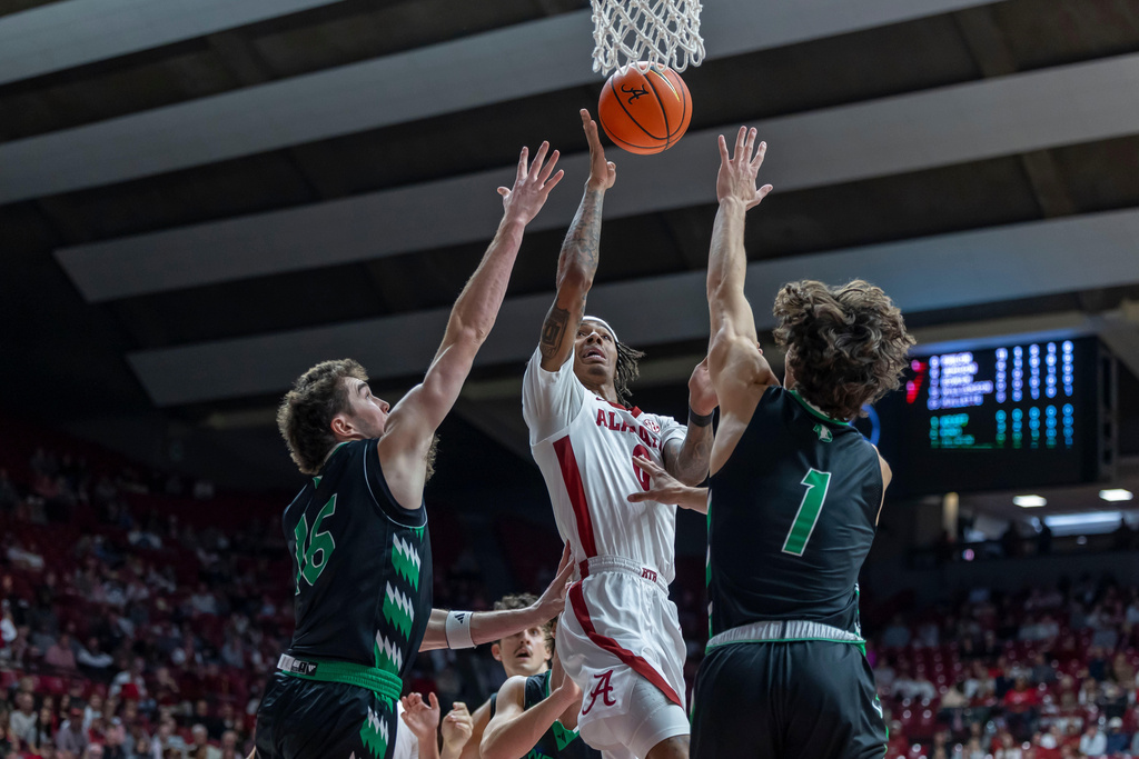 Alabama guard Labaron Philon Jr. (0) works to the basket against North Dakota guards Garrett Anderson (16) and Zach Kraft (1) during the first half of an NCAA college basketball game on Monday, Nov. 3, 2025, in Tuscaloosa, Ala. (AP Photo/Vasha Hunt)