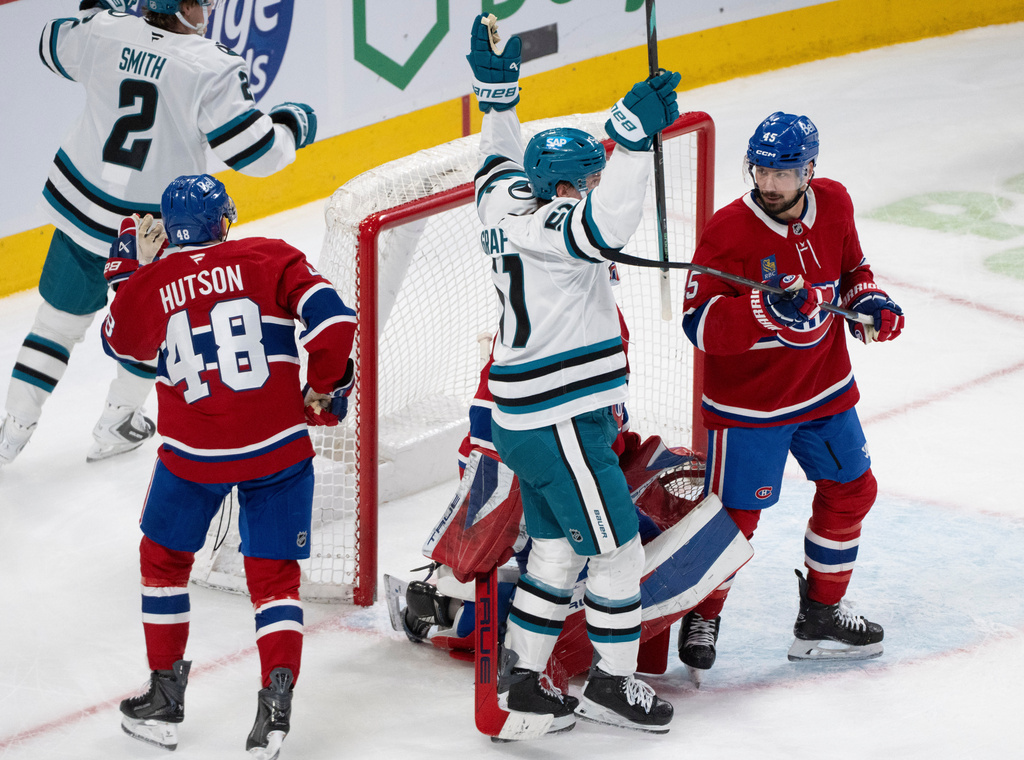 San Jose Sharks' Collin Graf (51) celebrates his goal in front of Montreal Canadiens goaltender Jakub Dobes (75), Lane Hutson (48) and Alexandre Carrier (45) during second period NHL hockey action in Montreal on Saturday, March 14, 2026. (Christinne Muschi/The Canadian Press via AP)