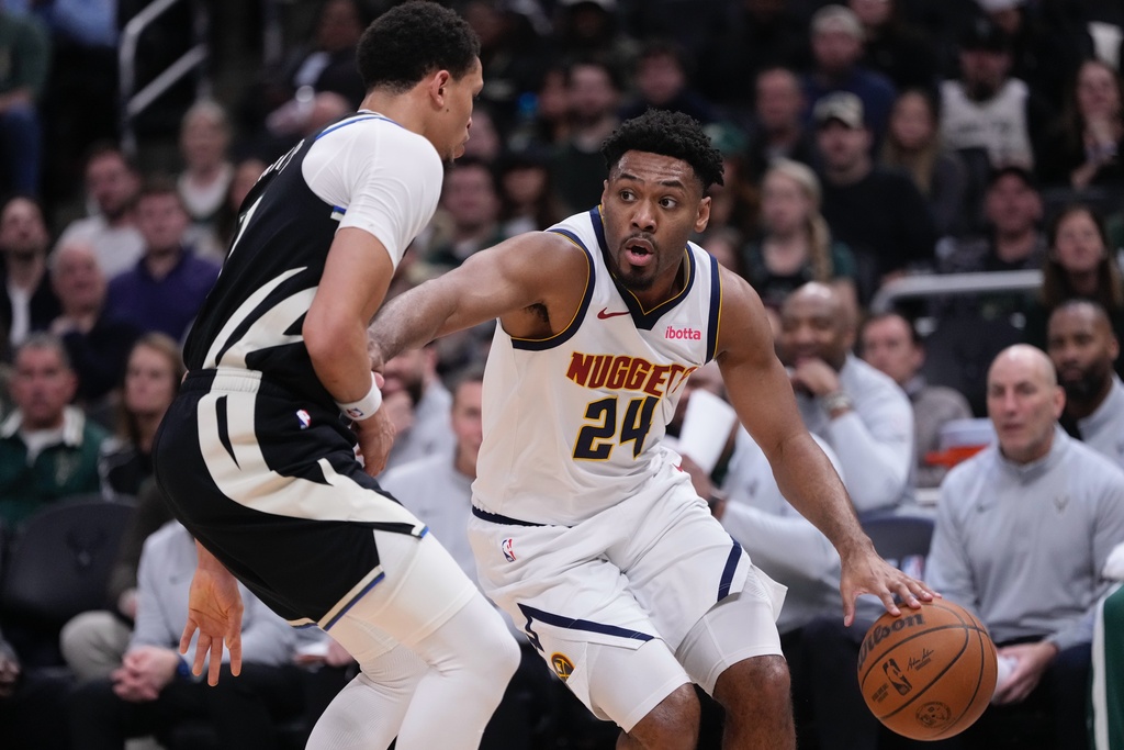Denver Nuggets' Jalen Pickett tries to get past Milwaukee Bucks' Ryan Rollins during the first half of an NBA basketball game Friday, Jan. 23, 2026, in Milwaukee. (AP Photo/Morry Gash)