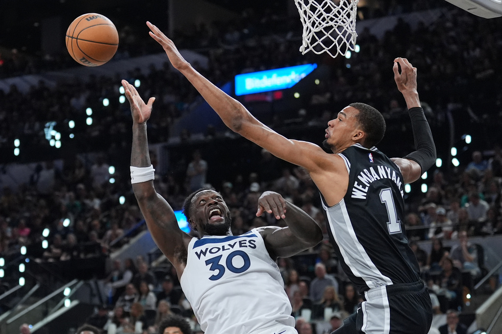 Minnesota Timberwolves forward Julius Randle (30) drives to the basket against San Antonio Spurs forward Victor Wembanyama (1) during the second half of Game 5 of an NBA basketball second-round playoffs series in Minneapolis, Tuesday, May 12, 2026. (AP Photo/Eric Gay)
