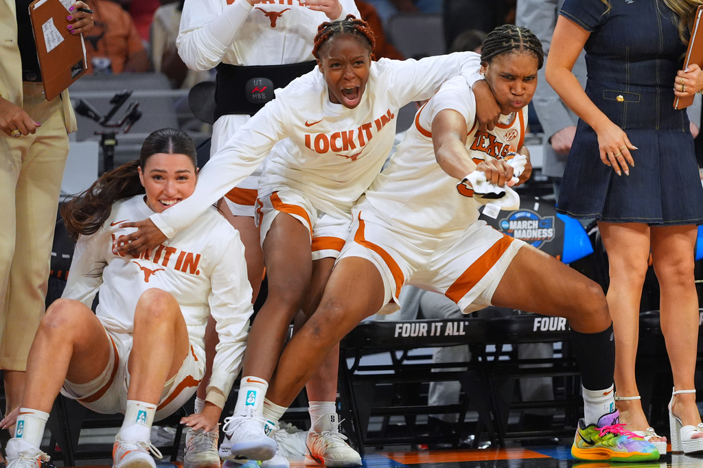 Texas players react on the bench against Michigan during the second half in the Elite Eight of the NCAA college basketball tournament, Monday, March 30, 2026, in Fort Worth, Texas. (AP Photo/LM Otero)