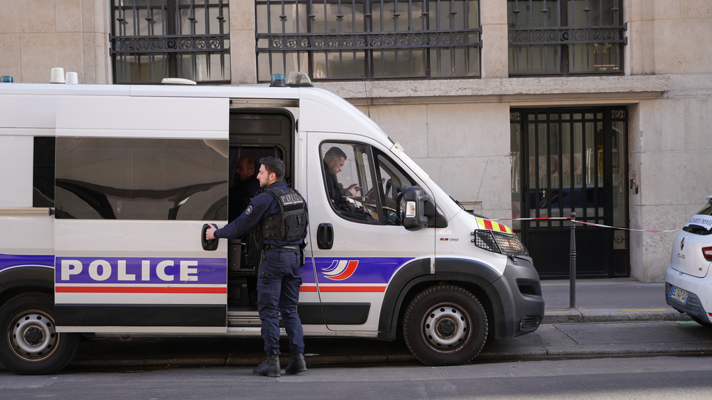 Police stand outside the Bank of America building in Paris, Saturday, March 28, 2026. (AP Photo/Nicolas Garriga)