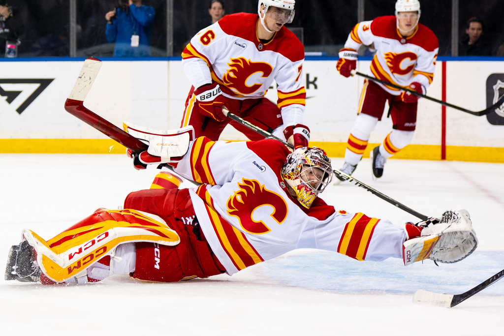 Calgary Flames goaltender Dustin Wolf falls as the New York Rangers score a third goal, during the second period of an NHL hockey game, Tuesday, March 10, 2026, in New York. (AP Photo/Angelina Katsanis)