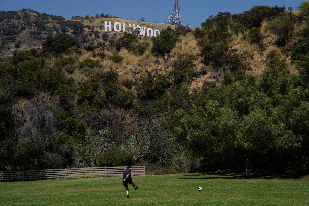 A person kicks a soccer ball in a park beneath the Hollywood sign in Los Angeles, May 8, 2026. (AP Photo/Jae C. Hong)