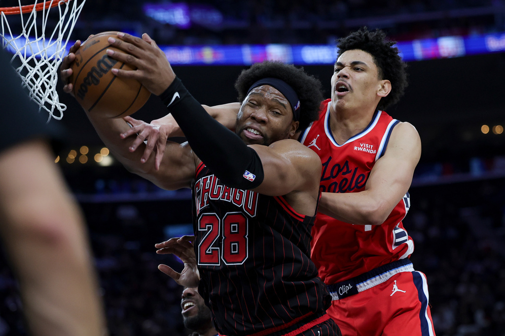 Chicago Bulls forward Guerschon Yabusele, left, and Los Angeles Clippers guard Kobe Sanders, right, vie for a rebound during the first half of an NBA basketball game Friday, March 13, 2026, in Inglewood, Calif. (AP Photo/Ryan Sun)