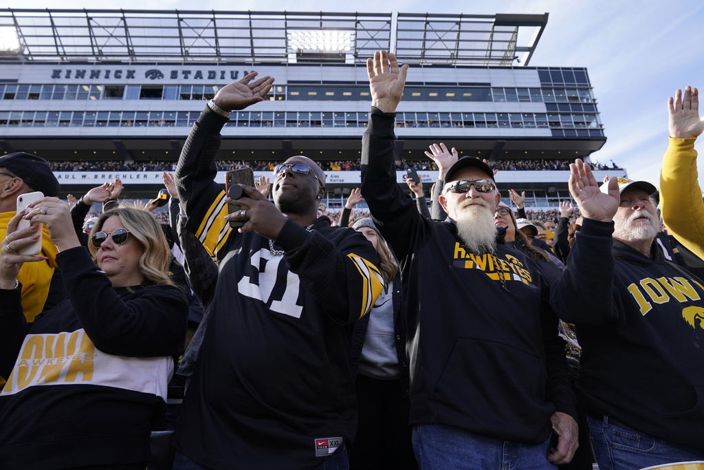 FILE - Iowa fans wave to children in the University of Iowa Stead Family Children's Hospital at the end of the first quarter of an NCAA college football game between Iowa and Illinois, Nov. 20, 2021, in Iowa City, Iowa. (AP Photo/Charlie Neibergall, File)