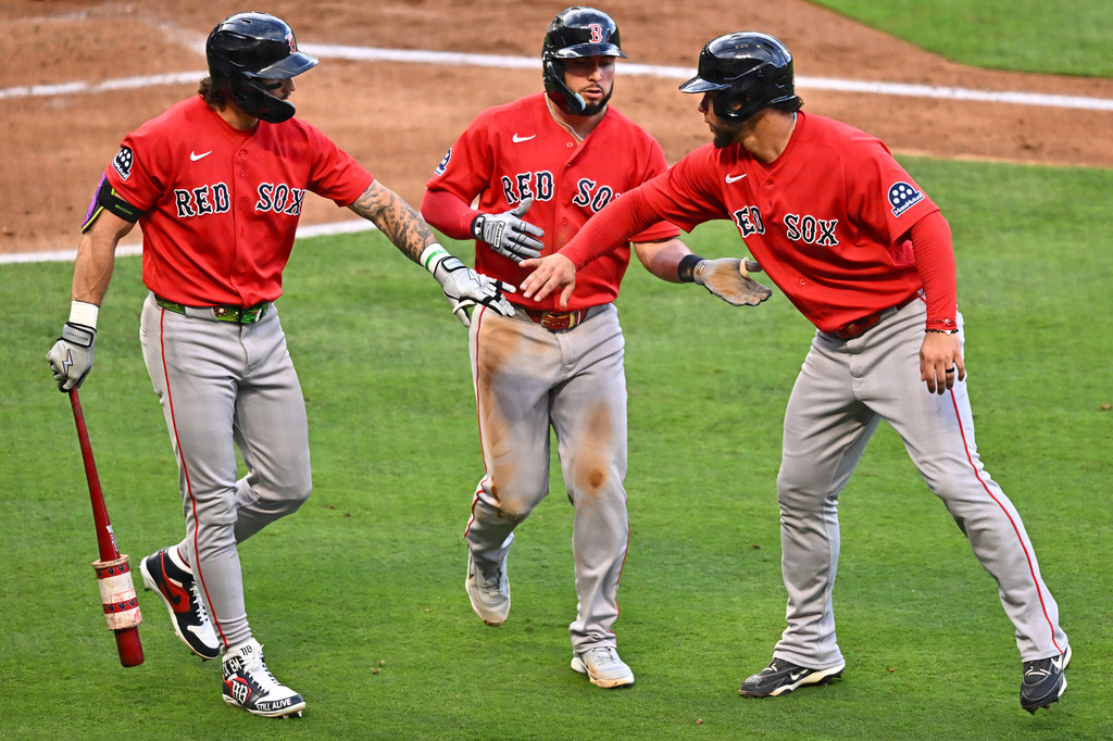 Boston Red Sox's Wilyer Abreu, center, and Willson Contreras, right, are greeted by Jarren Duran, left, after scoring during the third inning of a baseball game against the Los Angeles Angels, Friday, July 3, 2026, in Anaheim, Calif. (AP Photo/William Liang)