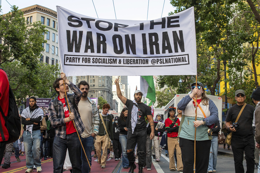 Protesters hold signs and chant anti-war slogans as they march toward Civic Center in San Francisco on Wednesday, April 8, 2026. (Dan Hernandez/San Francisco Chronicle via AP)