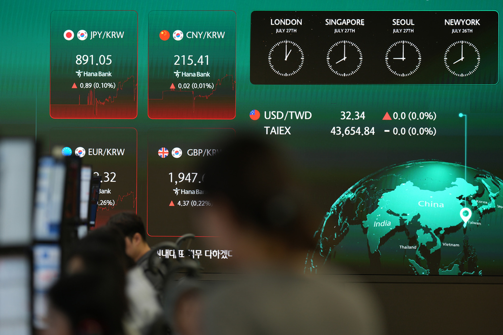 A dealer walks past near the screens showing the foreign exchange rates at a dealing room of Hana Bank in Seoul, South Korea, Monday, July 27, 2026. (AP Photo/Lee Jin-man)