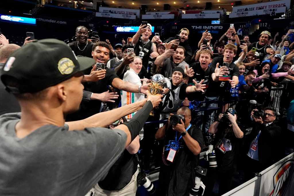 San Antonio Spurs forward Victor Wembanyama walks over to Spurs fans as he holds his MVP trophy as he celebrates after Game 7 of the Western Conference finals of the NBA basketball playoffs series win against the Oklahoma City Thunder, Saturday, May 30, 2026, in Oklahoma City. (AP Photo/Tony Gutierrez)