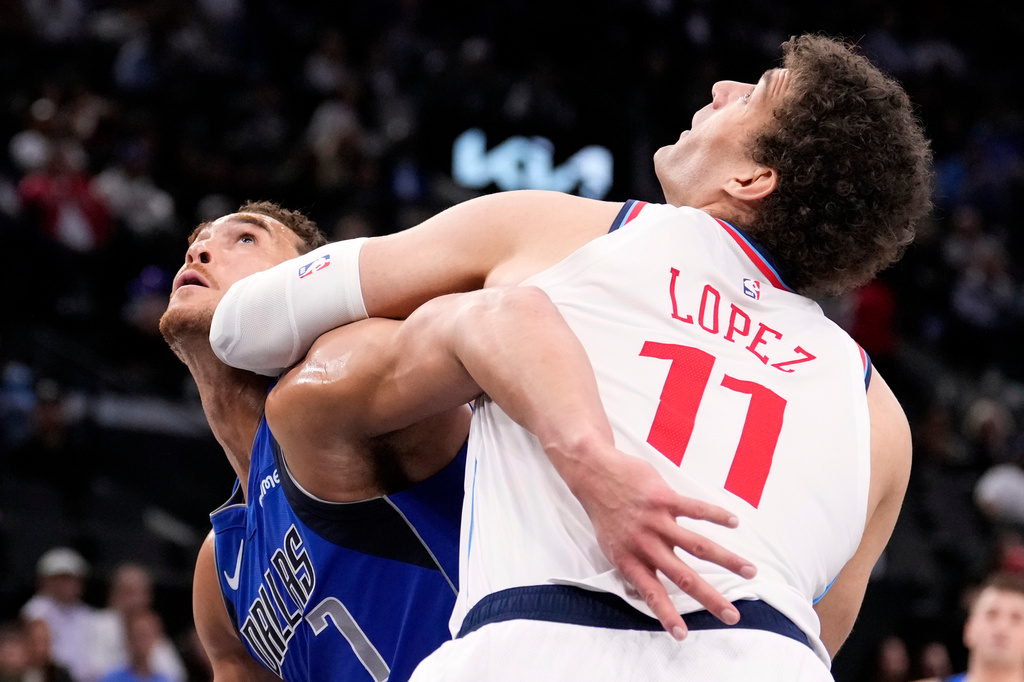 Dallas Mavericks forward Dwight Powell, left, and Los Angeles Clippers center Brook Lopez battle for a rebound during the first half of an NBA basketball game Tuesday, April 7, 2026, in Inglewood, Calif. (AP Photo/Mark J. Terrill)