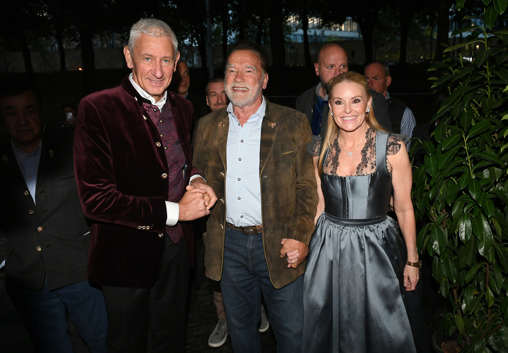 From left, Siegfried Able, Arnold Schwarzenegger, and Heather Milligan participate in the 190th Oktoberfest on Friday, Sept. 26, 2025, in Munich, Germany. (Felix Hörhager/dpa via AP)