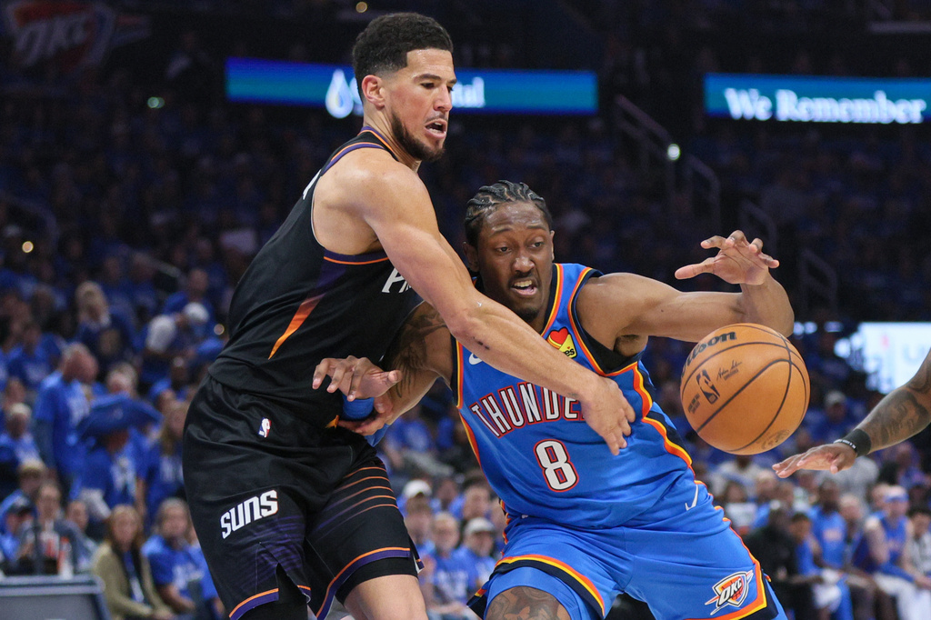 Phoenix Suns guard Devin Booker, left, tries to steal the ball from Oklahoma City Thunder guard Jalen Williams (8) during the second half in Game 1 of a first-round NBA playoffs basketball series Sunday, April 19, 2026, in Oklahoma City. (AP Photo/Nate Billings)