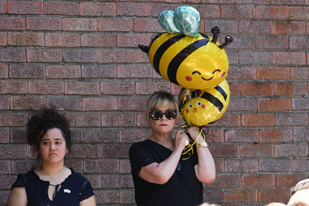 A mourner holds bumblebee balloons at the funeral of Bondi Beach mass shooting victim 10-year-old Matilda, whose last name is being withheld at the request of her family, in Sydney, Thursday, Dec. 18, 2025. (AP Photo/Steve Markham)