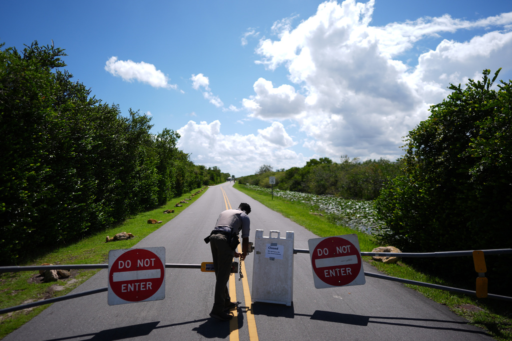 National Park Service law enforcement ranger Greg Freeman opens a locked gate closing vehicle access to the Shark Valley section of Florida's Everglades National Park, as he drives into the park, Wednesday, Oct. 1, 2025. (AP Photo/Rebecca Blackwell)