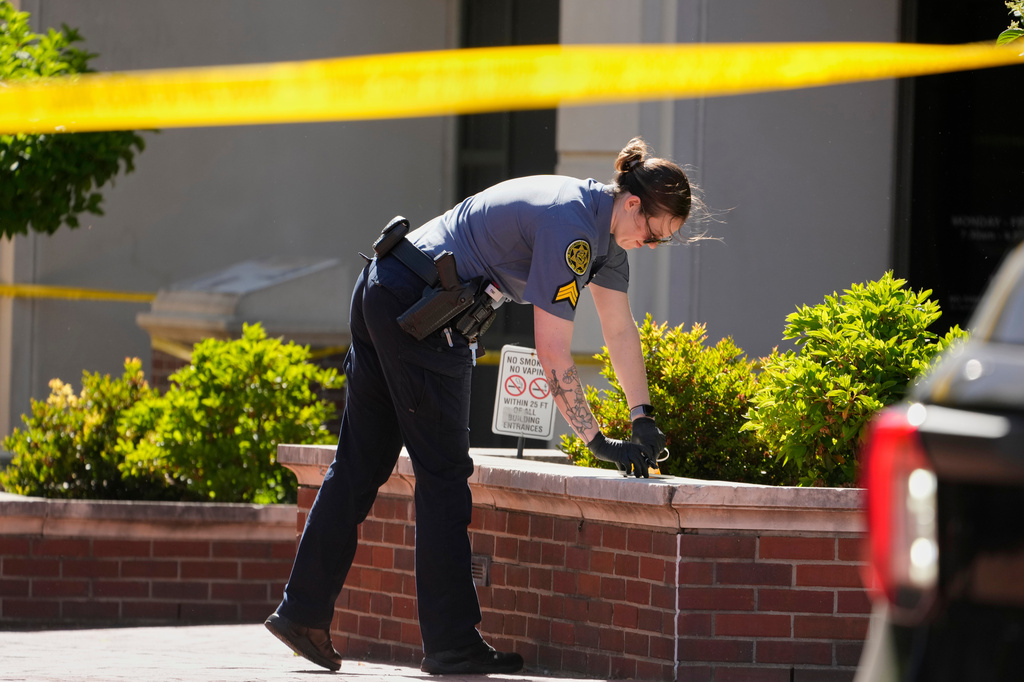 A Sheriff's deputy investigates a shooting scene outside the Montgomery County Courthouse, Wednesday, May 13, 2026, in Clarksville, Tenn. (AP Photo/George Walker IV)