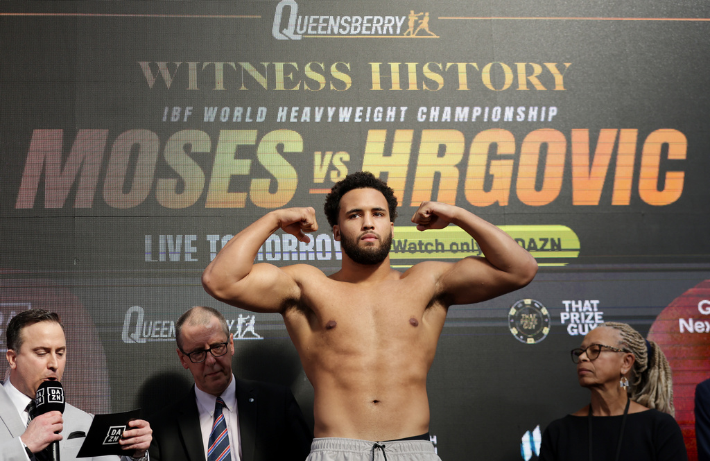 Boxer Moses Itauma, center, flexes during his weigh-in, Friday, Aug. 28, 2026, in London, ahead of his IBF heavyweight championship bout against Filip Hrgovic. (Steven Paston/PA via AP)