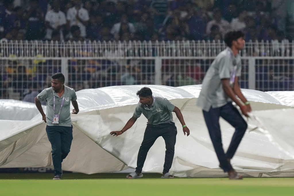 Ground staff pull in rain covers to the field as it rains during the Indian Premier League cricket match between Kolkata Knight Riders and Punjab Kings in Kolkata , India, Monday, April 6, 2026. (AP Photo/Bikas Das)