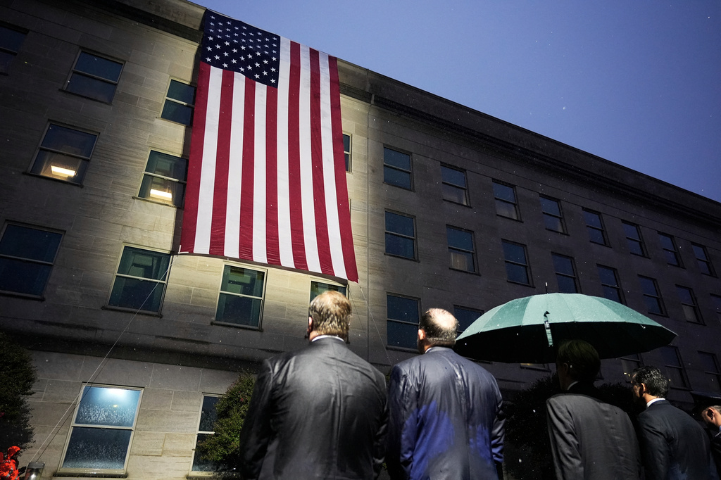 Secretary of Defense Pete Hegseth, Chairman of the Joint Chiefs, Air Force Gen. Dan Caine, and other officials, watch as the flag is unfurled at the Pentagon, Friday, Sept. 11, 2026 in Arlington, Va. (AP Photo/Manuel Balce Ceneta)