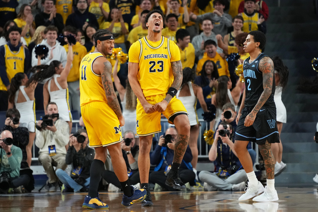 Michigan forward Yaxel Lendeborg, center, celebrates near guard Roddy Gayle Jr., left, and Villanova guard Bryce Lindsay after scoring during the first half of an NCAA college basketball game, Tuesday, Dec. 9, 2025, in Ann Arbor, Mich. (AP Photo/Ryan Sun)