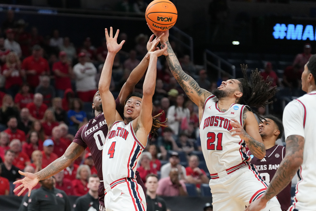 Texas A&M guard Marcus Hill (0) tries to get to a rebound before Houston guards Kingston Flemings (4) and forward Emanuel Sharp (21) during the first half in the second round of the NCAA college basketball tournament Saturday, March 21, 2026, in Oklahoma City. (AP Photo/Kyle Phillips)