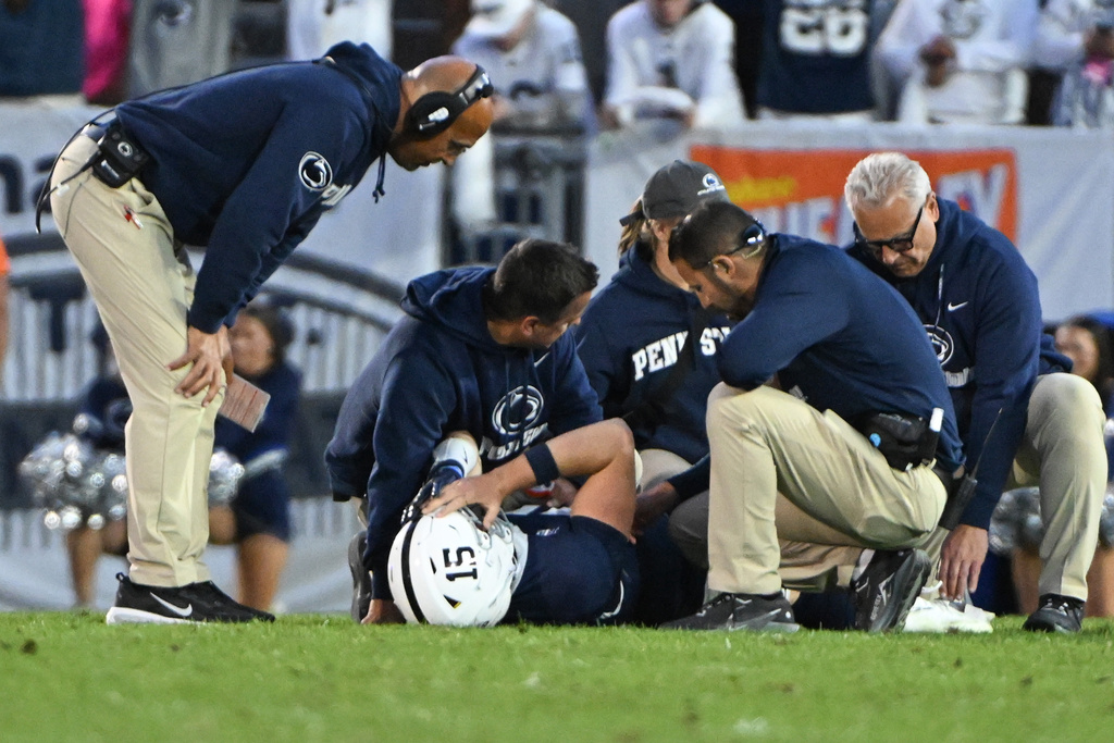 Penn State head coach James Franklin looks over quarterback Drew Allar (15) as he lays on the field injured during the fourth quarter of an NCAA college football game against Northwestern, Saturday, Oct. 11, 2025, in State College, Pa. (AP Photo/Barry Reeger)