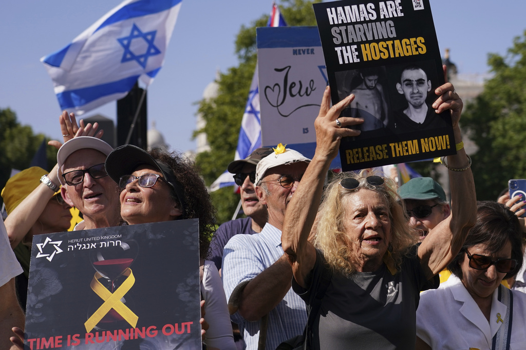 Demonstrators hold placards as they take part in the March for Hostages, in London, Sunday, Aug. 10, 2025. (AP Photo/Alberto Pezzali)