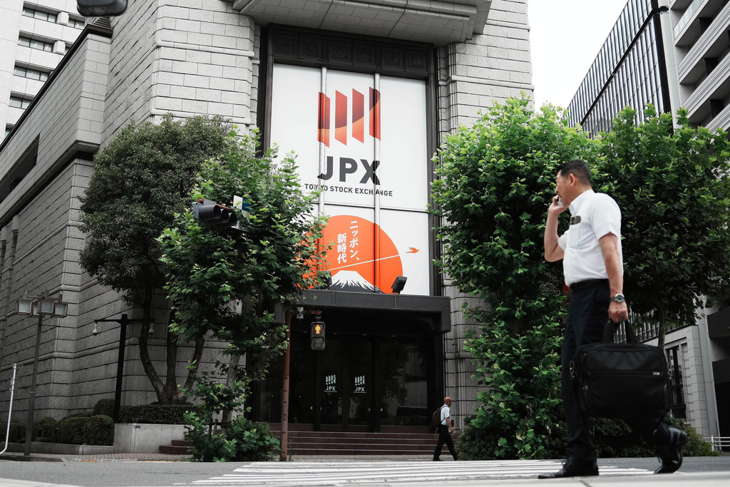 FILE - A person walks in front of Tokyo Stock Exchange building Friday, July 11, 2025, in Tokyo. (AP Photo/Eugene Hoshiko, File)