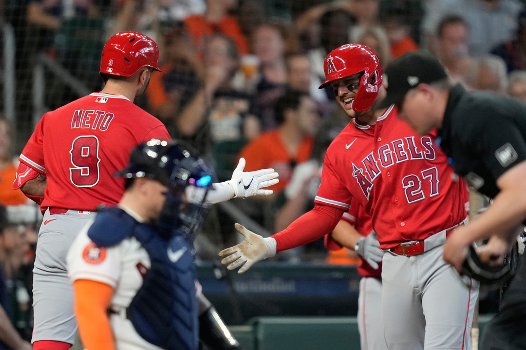 Los Angeles Angels' Zach Neto (9) celebrates with designated hitter Mike Trout (27) after hitting a home run during the fourth inning of a baseball game against the Houston Astros in Houston, Sunday, March 29, 2026. (AP Photo/Ashley Landis)