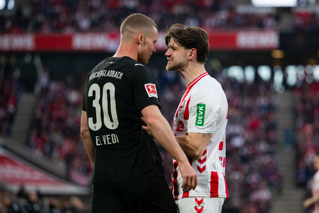 Cologne's Jan Thielmann, left, and Moenchengladbach's Nico Elvedi, left, during the German Bundesliga soccer match between 1. FC Cologne and Borussia Moenchengladbach in Cologne, Germany, Saturday, March 21, 2026. (Marius Becker/dpa via AP)