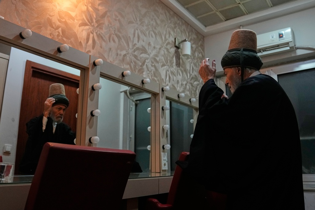 Mim Kemal Bulent Oke, head of dervish order dresses up before a Sheb-i Arus ceremony at a municipality cultural center in Istanbul, Turkey, Wednesday, Dec. 17, 2025, to commemorate the death of 13th century Islamic scholar, poet and Sufi mystic Jalaladdin Rumi.(AP Photo/Khalil Hamra)