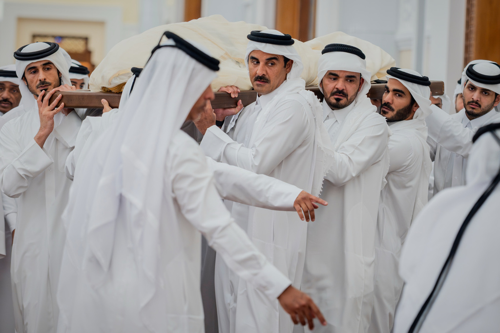 In this picture released by the Qatar Amiri Diwan media office, Qatari Emir Sheikh Tamim bin Hamad Al Thani helps carry the bier bearing the body of his father, Qatar's former ruler Sheikh Hamad bin Khalifa Al Thani, with other mourners for a funeral prayer at the Mohammed bin Abdulwahab Mosque in Doha, Qatar, Sunday, July 12, 2026. (Qatar Amiri Diwan via AP)