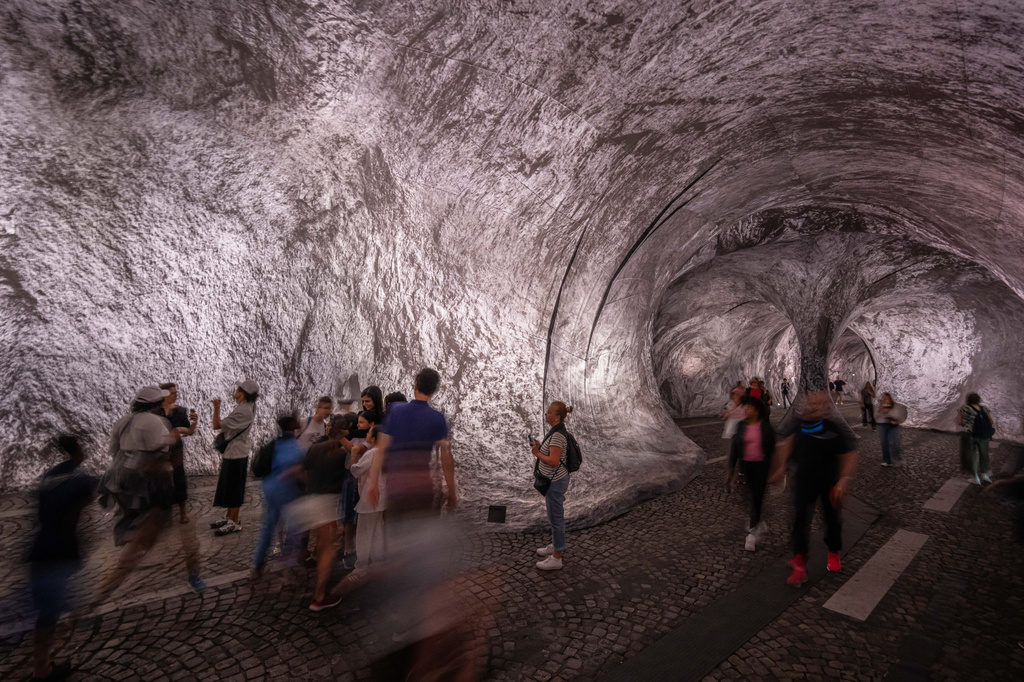 Visitors walk into the artwork "The Pont Neuf Cave" by French street artist JR on the Pont Neuf bridge, Tuesday, June 16, 2026, in Paris, open to the public from June 15 to 28. (AP Photo/Aurelien Morissard)