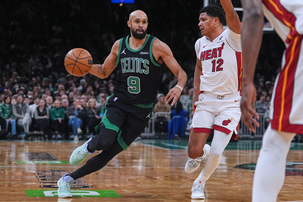 Boston Celtics guard Derrick White (9) drives to the basket against Miami Heat guard Dru Smith (12) during the first half of an NBA basketball game, Friday, Feb. 6, 2026, in Boston. (AP Photo/Charles Krupa)