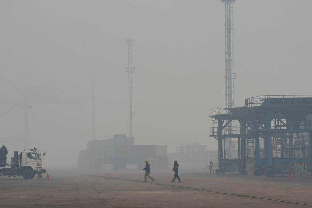 Dock workers walk amid the thick haze from forest fires at Kijing Port in Mempawah, West Kalimantan, Indonesia, Thursday, Sept. 10, 2026. (AP Photo/Tatan Syuflana)