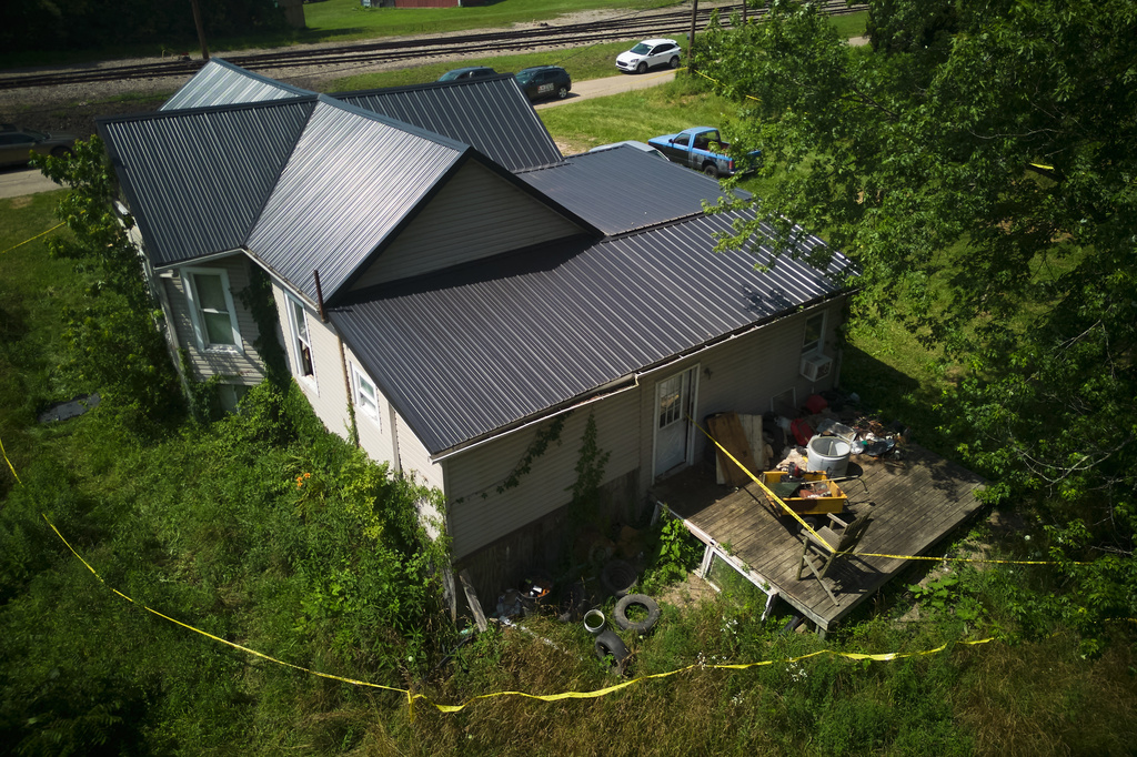 Police tape surrounds a home where authorities say they removed 16 children and arrested four adults in Hamden, Ohio, Wednesday, July 1, 2026. (AP Photo/Carolyn Kaster)